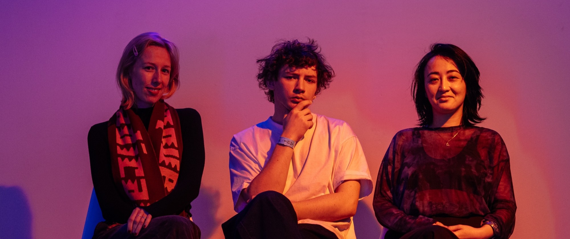 Tři osoby sedící vedle sebe.